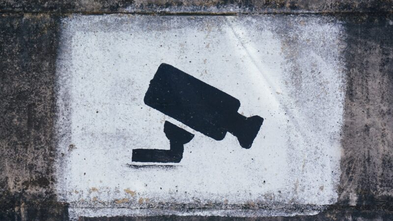 Black and white drawing of surveillance camera on concrete wall