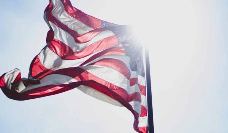 American flag with sun behind it