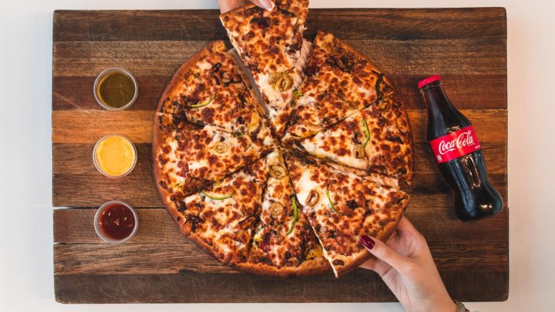 A photo of people sharing pizza