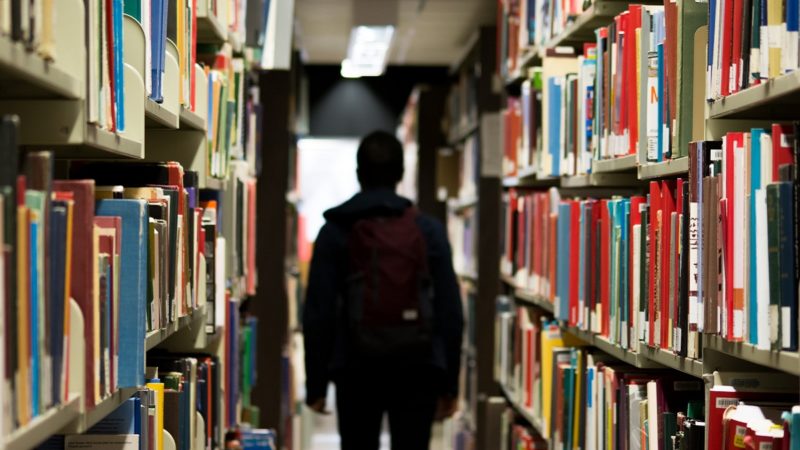 Student in a library with back turned