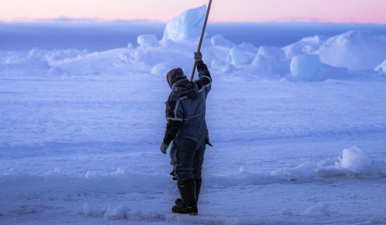 Sea ice fisherman checking the sea ice if it is safe