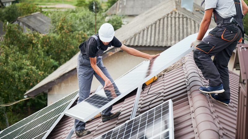 Men installing solar panels on roof