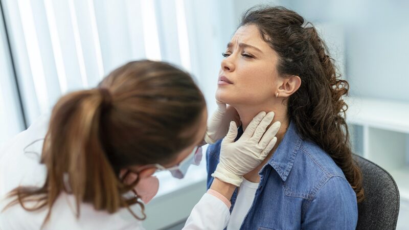 Woman being screen for thyroid condition in neck